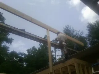 Carpenter setting a ridge beam over a new addition frame — Ice Dam Removal by Roofing Brothers in West Blocton