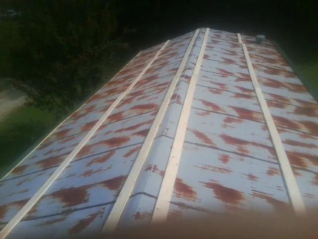 Rusted metal roof panels with new wood purlins before replacement — Storm Damage Roof Repair in West Blocton by Roofing Brothers