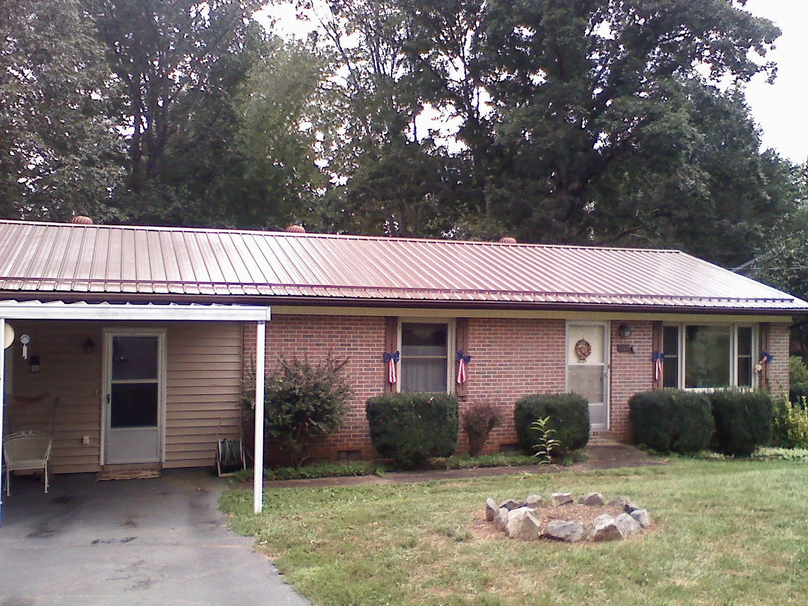 Bronze metal roof and carport on a brick ranch home — Roof Repair work by our crew in West Blocton