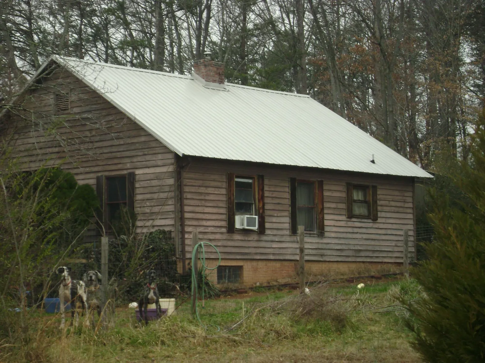 White metal roof on an old wood sided farmhouse, from a Metal Roof Installation job in West Blocton